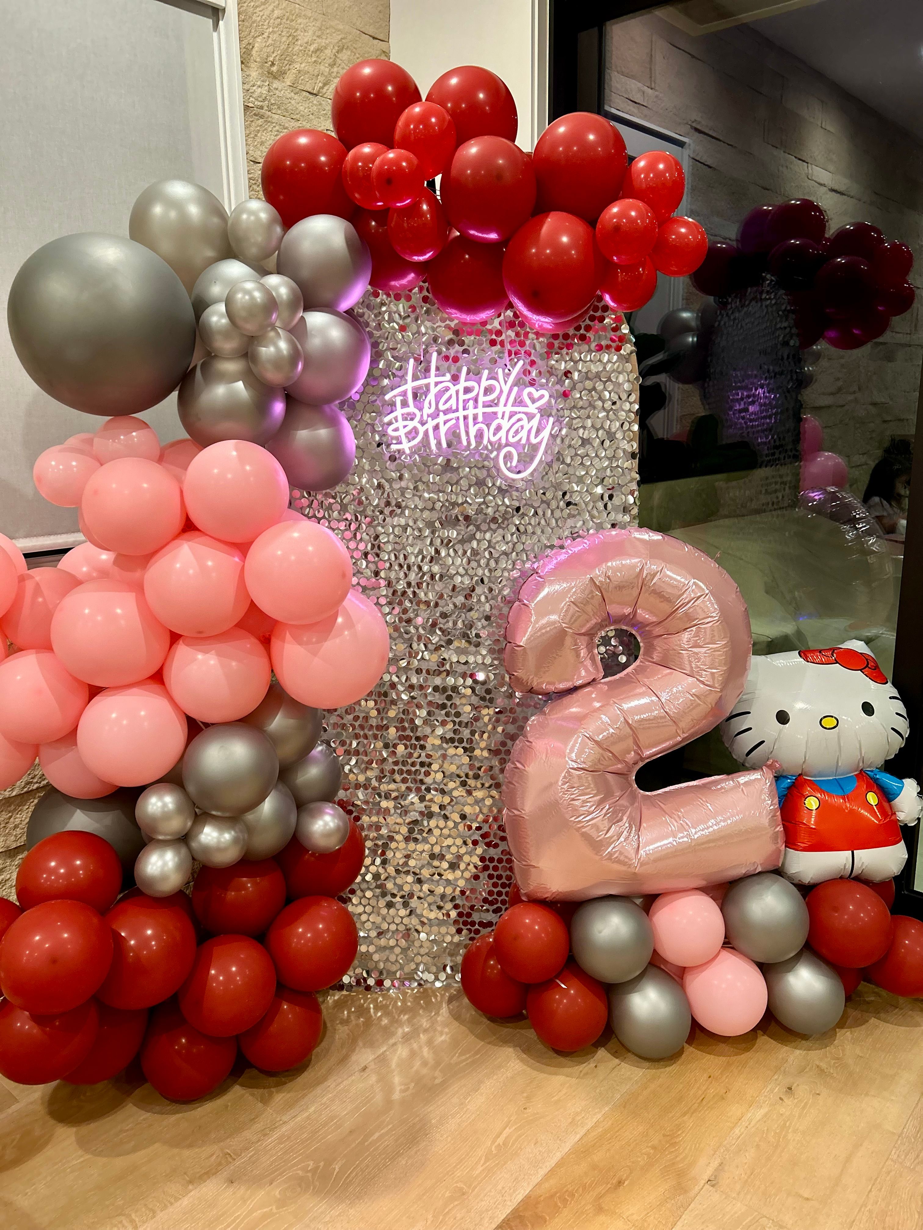 Hello Kitty themed balloon garland with pink, red and silver balloons