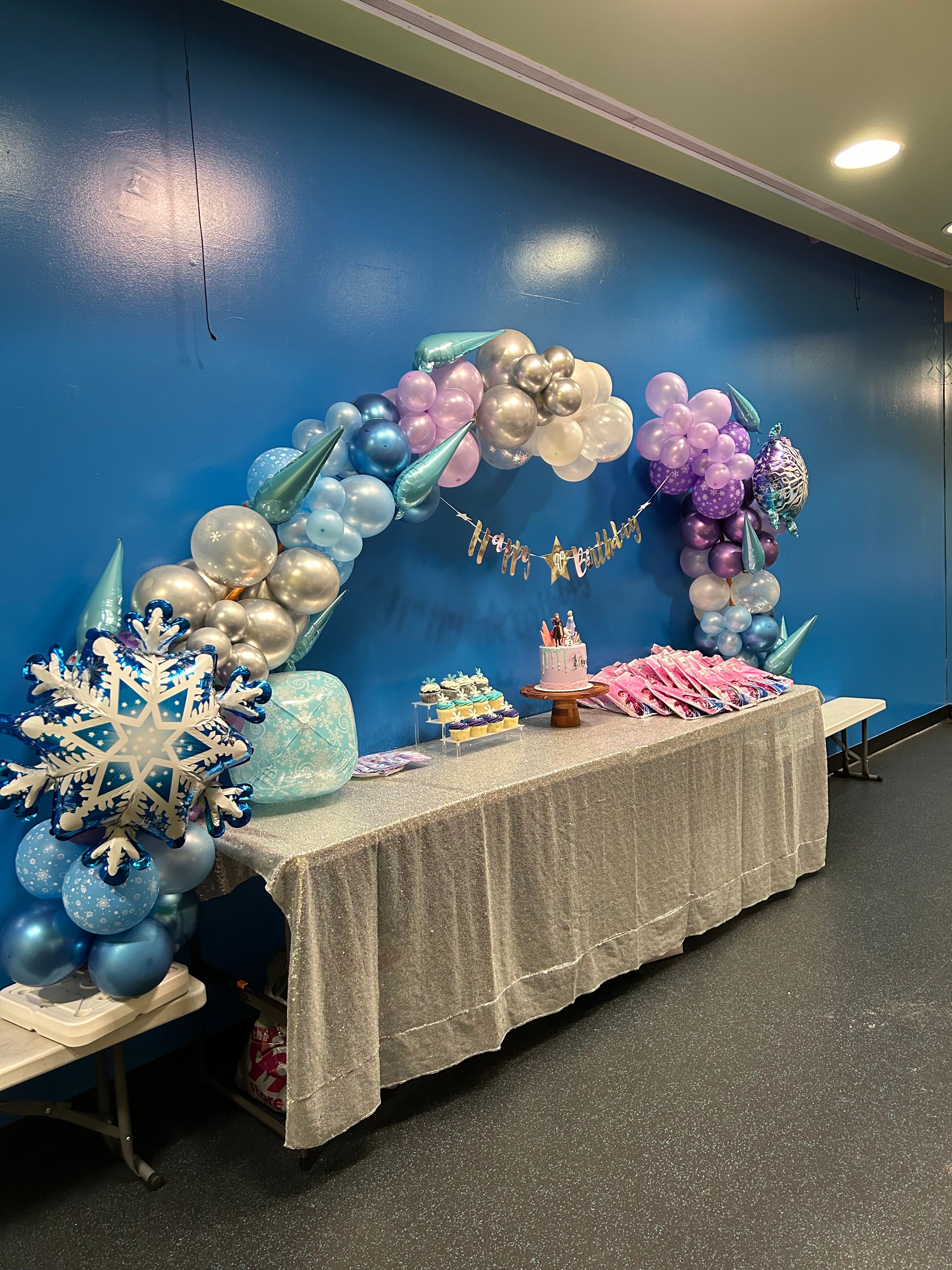 Stunning Frozen themed balloon garland overflowing with blue, purple and silver balloons by Confetti & Charms